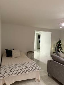a white bedroom with a bed and a christmas tree at Nietos Aurora in Ylitornio