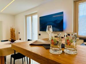 two wine glasses sitting on top of a wooden table at Nos Sweet Home in Dimaro