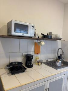 a microwave sitting on a shelf above a kitchen counter at NEW! Loft in Cancun Center 5 mins from the ADO in Cancún +7 photos