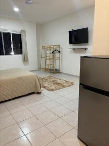 a room with a bed and a tv on a wall at NEW! Loft in Cancun Center 5 mins from the ADO in Cancún