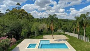 een afbeelding van een zwembad in een tuin met bomen bij Refúgio de Luxo à beira do Lago Passaúna, in Ferraria