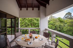 een eetkamer met een tafel en stoelen op een balkon bij Refúgio de Luxo à beira do Lago Passaúna, in Ferraria