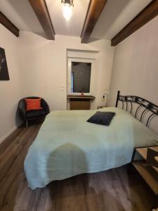 una camera da letto con un letto grande e una sedia di Gîte, 6 personnes le louveteau a Muhlbach-sur-Bruche