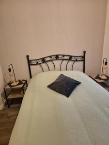 un grande letto con un cuscino nero sopra di Gîte, 6 personnes le louveteau a Muhlbach-sur-Bruche Altre 8 foto