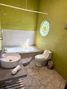 a bathroom with a tub and a toilet and a sink at Casa La Vista in San Miguel de Allende