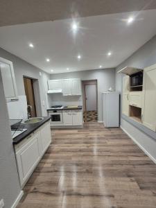 una cucina con mobili bianchi e pavimento in legno di Gîte, 6 personnes le louveteau a Muhlbach-sur-Bruche