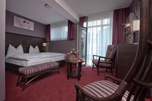a hotel room with a bed and a chair at Göbel's Hotel AquaVita in Bad Wildungen