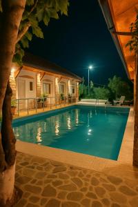 a swimming pool in a house at night at Guesthouse Lord Byron in Tepelenë