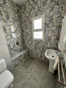 a bathroom with a toilet sink and a window at Appartement Vue de Mer Pied dans l'eau in Gabès