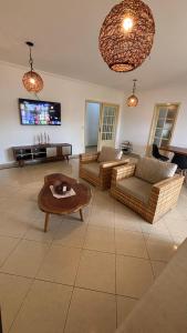 a living room with couches and a coffee table at Villa das Araras Residence in Porto Seguro