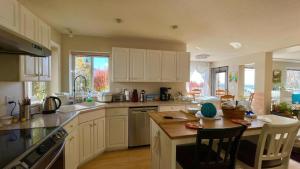 a kitchen with white cabinets and a table with chairs at warm house2 in Coquitlam