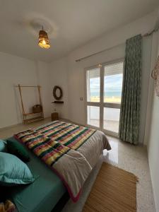a bedroom with a large bed and a window at Appartement Vue de Mer Pied dans l'eau in Gabès