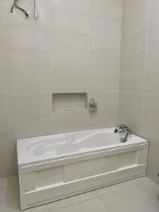 a white bath tub in a white bathroom at Bomo Apartment in Ikota