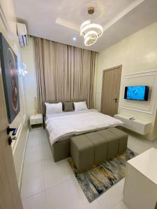 a bedroom with a bed and a flat screen tv at Bomo Apartment in Ikota