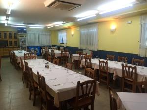 Hostal Tio Pepe I في Bembibre: غرفة طعام مع طاولات وكراسي مع مفارش بيضاء
