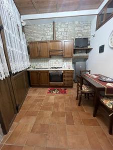 a kitchen with wooden cabinets and a table and a dining room at Appartamento Barone in Gubbio