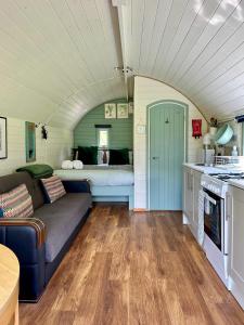a living room with a couch and a kitchen at The Mainstay Pod at Hidden Wood Glamping in Corsley +10 photos