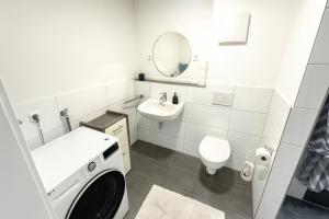 a white bathroom with a sink and a washing machine at Deluxe Apartment Seeblick in Friedrichshafen +12 photos