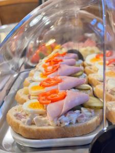 a display of sandwiches with meats and vegetables on bread at Sport hotel POMI in Harrachov