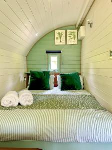 a bedroom with a bed with green walls at The Mainstay Pod at Hidden Wood Glamping in Corsley