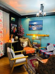 a living room with blue walls and a couch and chairs at WN Hilltop B&B by Smart Stay 2600 in Baguio