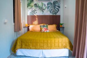 Eco Suites El Zonte في لا ليبرتاد: غرفة نوم بسرير مع مفرش اصفر +48 صورة