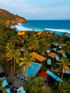 Eco Suites El Zonte في لا ليبرتاد: اطلالة جوية على منتجع فيه نخيل والمحيط