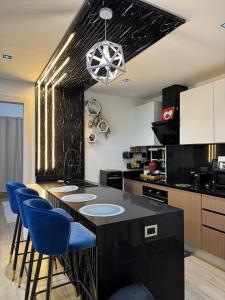 a kitchen with a black island with blue bar stools at Downtown Punta Cana-Welcome to our Love Nest! in Punta Cana