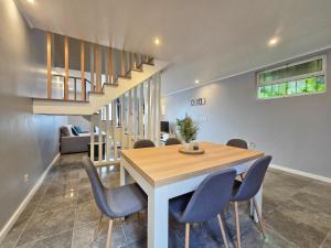 een eetkamer met een tafel en stoelen en een trap bij Casa da Maré Azul in São Roque