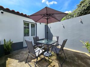 een tafel en stoelen met een parasol op een terras bij Casa da Maré Azul in São Roque