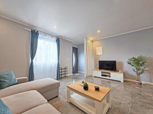 een woonkamer met een bank en een tv bij Casa da Maré Azul in São Roque