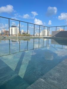 uma piscina de água com uma cidade ao fundo em Excelente apartamento a passos da praia em Cabedelo mais 34 fotografias