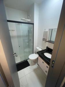 um banheiro com chuveiro, vaso sanitário e pia em Excelente apartamento a passos da praia em Cabedelo