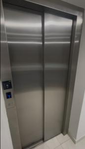 um elevador com uma porta de metal num quarto em Excelente apartamento a passos da praia em Cabedelo