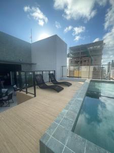 uma varanda com piscina no topo de um prédio em Excelente apartamento a passos da praia em Cabedelo