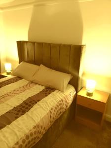 Un dormitorio con una cama y dos mesitas de noche con lámparas. en High class accommodation, en Bury 3 fotos más