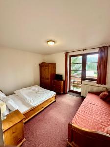 a bedroom with two beds and a window at Sport hotel POMI in Harrachov