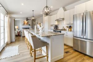 a kitchen with white cabinets and a large island with bar stools at Scenic Sandia Mtn Views! Cozy Rio Rancho Retreat in Paradise Hills