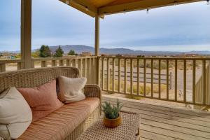 a wicker couch sitting on a deck with a view at Scenic Sandia Mtn Views! Cozy Rio Rancho Retreat in Paradise Hills