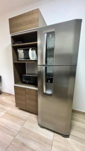 Casa Confortável em Localização Estratégica في فوز دو إيغواسو: ثلاجة من الفولاذ المقاوم للصدأ في مطبخ مع ميكروويف