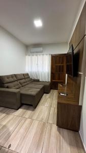 Casa Confortável em Localização Estratégica في فوز دو إيغواسو: غرفة معيشة مع أريكة وتلفزيون بشاشة مسطحة