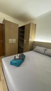 Casa Confortável em Localização Estratégica في فوز دو إيغواسو: سرير أبيض كبير عليه منشفة زرقاء