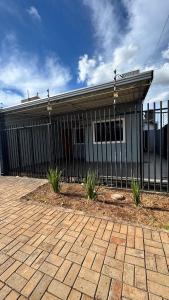 Casa Confortável em Localização Estratégica في فوز دو إيغواسو: مبنى امامه سياج