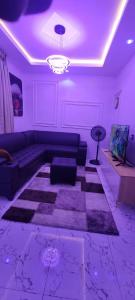 a living room with a couch and purple lighting at Larj residence in Lagos