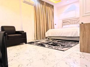 a bedroom with a bed and a chair at Larj residence in Lagos