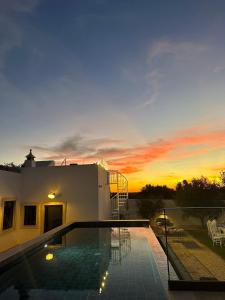 een huis met een zwembad bij zonsondergang bij Monte Gerações - Complete House - Heated pool - Typical Algarvian - close to Quinta Lago Vale Lobo and Vilamoura in Almancil