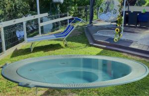 MuraszemenyeMuraszemenye tóparti horgász nyaraló的院子里有个游泳池，旁边有把椅子和一个秋千。