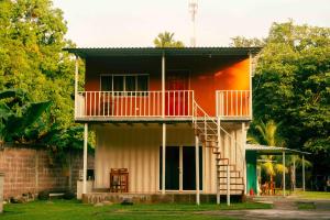 a house with a balcony and a staircase at Hotel Castillo Blanco in El Zonte