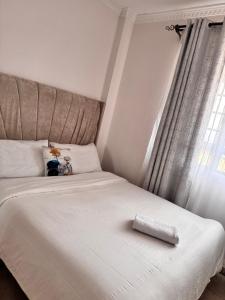 a white bed with a piece of paper on it at Luxx Homes Properties in Ruiru
