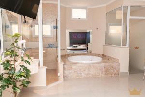 een grote badkamer met een bad en een wastafel bij Prime Motel Piracicaba in Piracicaba